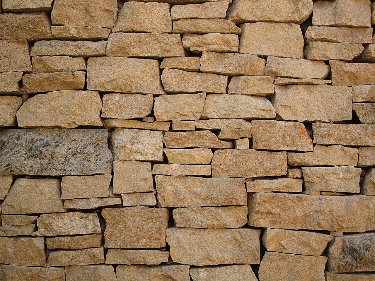 hero-img-02 Close-up of a rustic stone wall showcasing natural colors and textures.