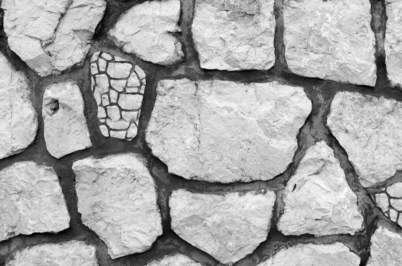 about-01 Close-up of a black and white textured stone wall with irregular shapes and patterns.